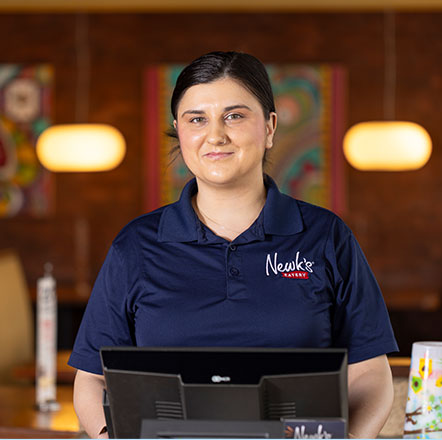 Smiling Newk's employee behind a register